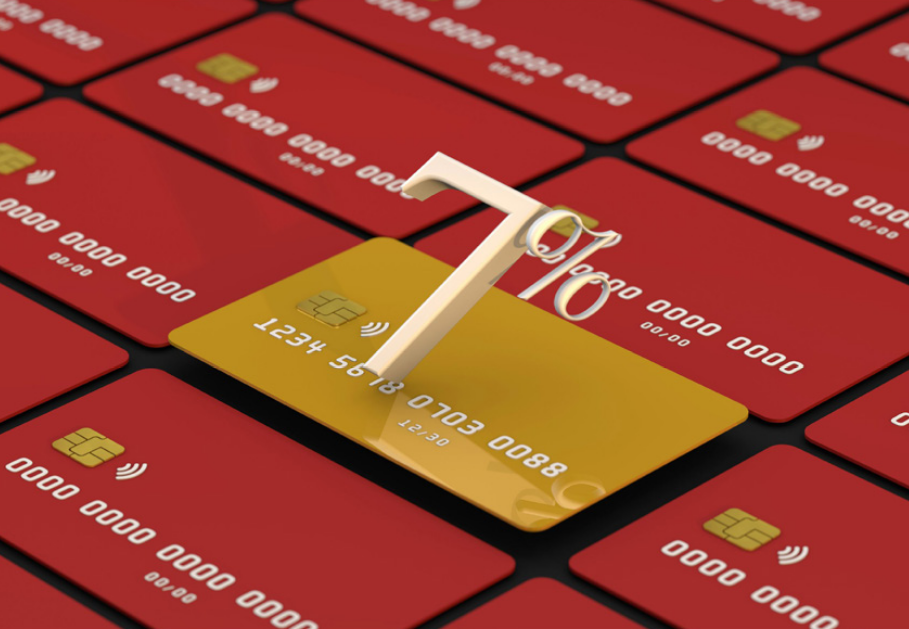 Multiple red credit cards and one that is gold. On top of the gold card there is a graphic that reads 7%.