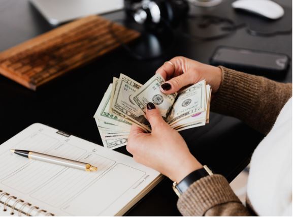 Someone counting out money to pay for something