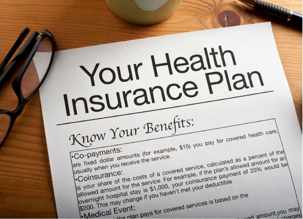 Document titled Your Health Insurance Benefits lying on a desk