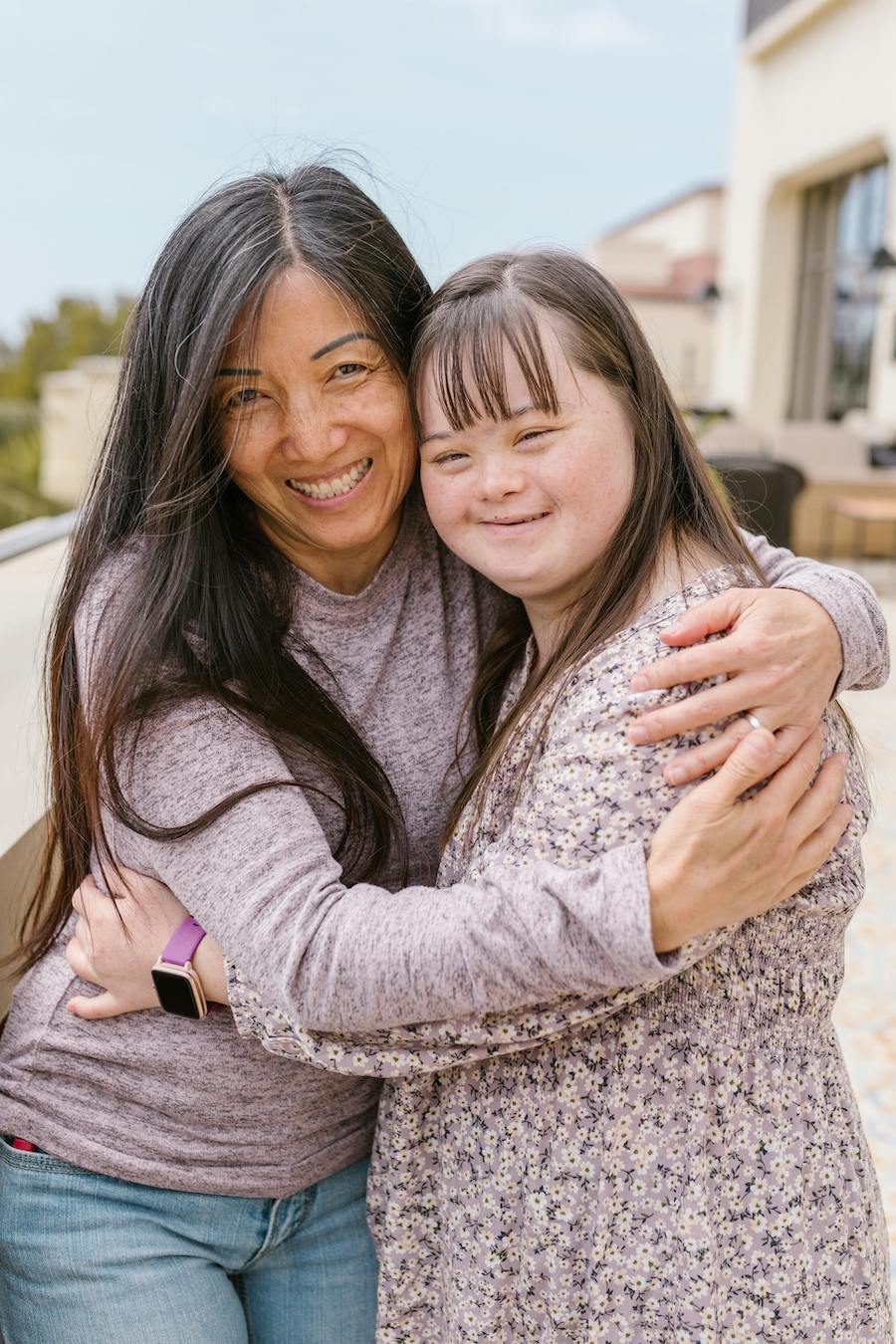 A young Pacific Islander woman hugging an older Pacific Islander woman.