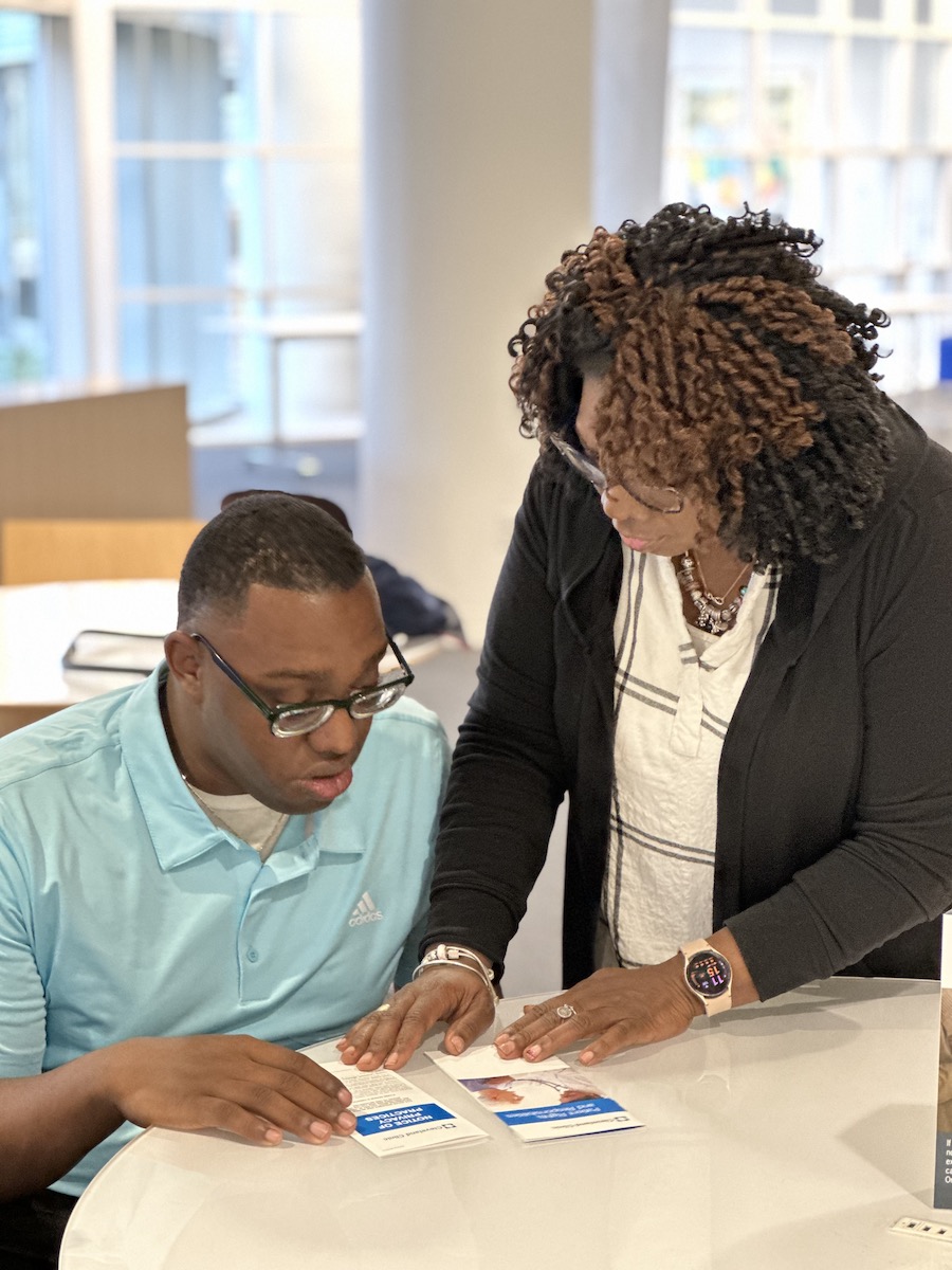 A young African American man looking at Patient Rights and Privacy brochures with an African American woman.