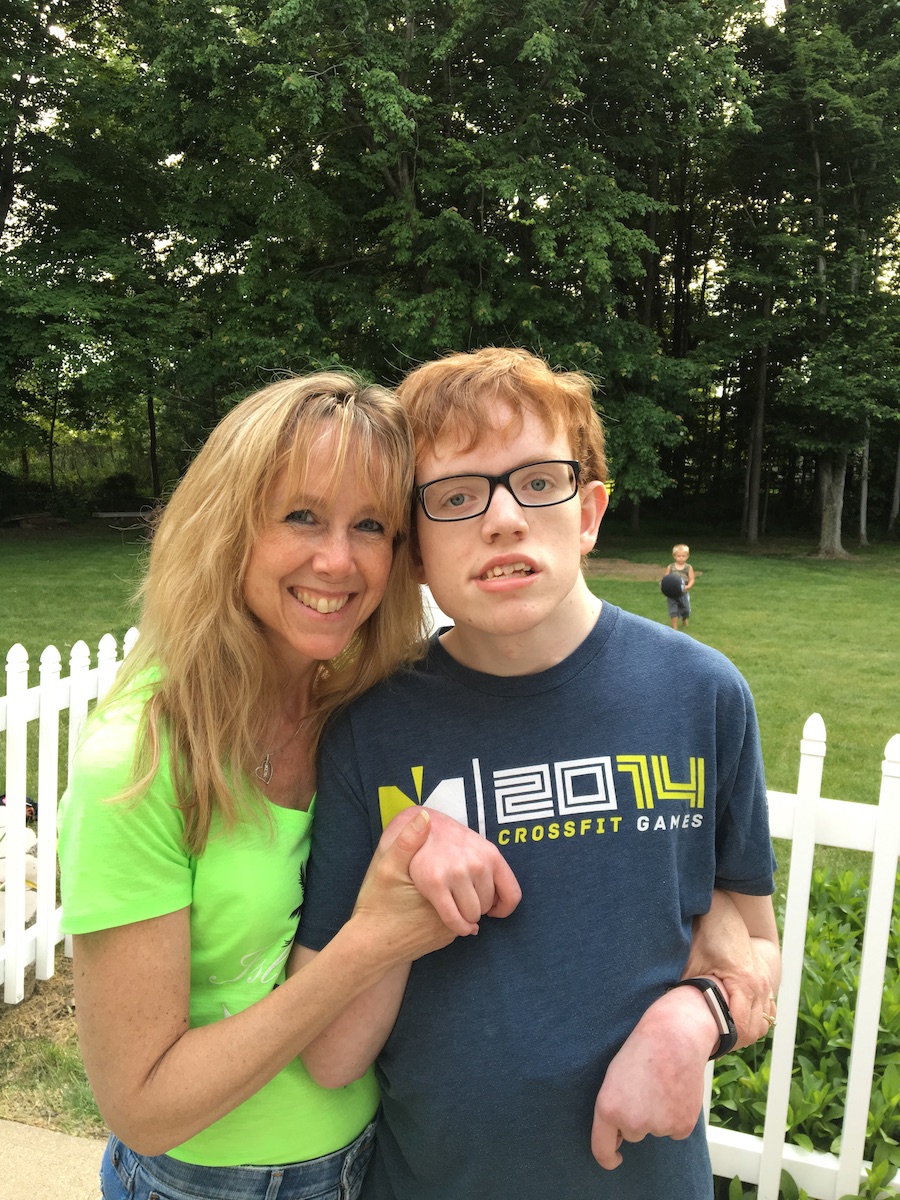 A young White man and a White woman standing outside smiling.